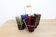 Set of 6 coloured glasses in their brass holder, basket