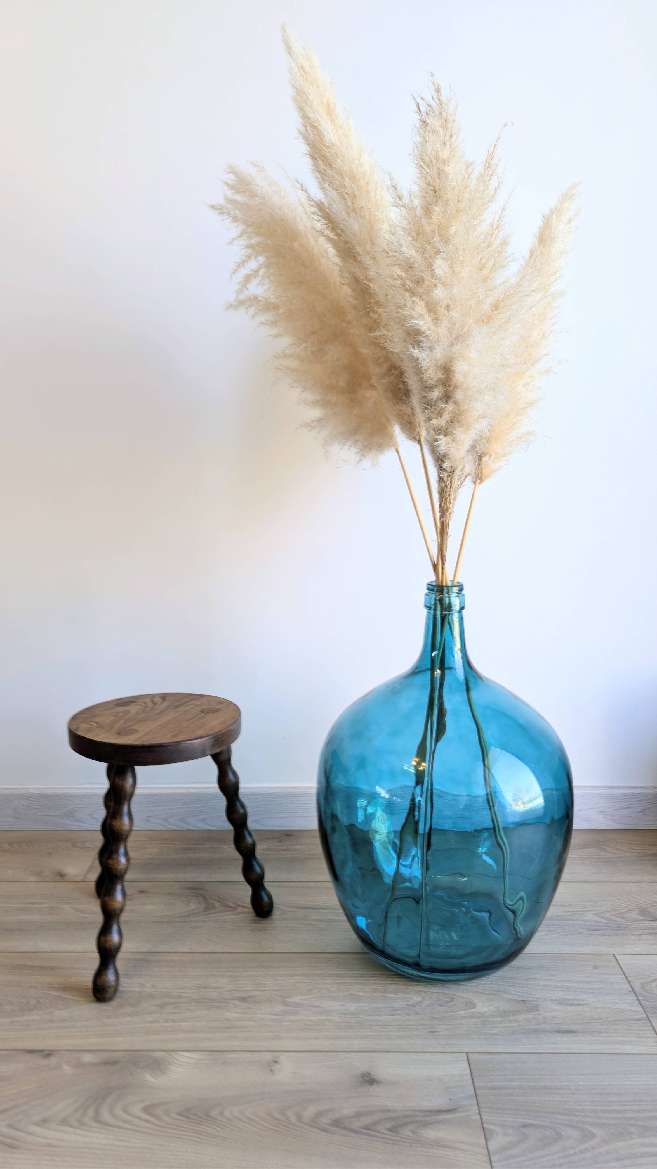 Small wooden tripod stool with turned legs, country style.