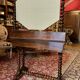 Antique English mahogany dressing table with carved details, black marble, and mirror.