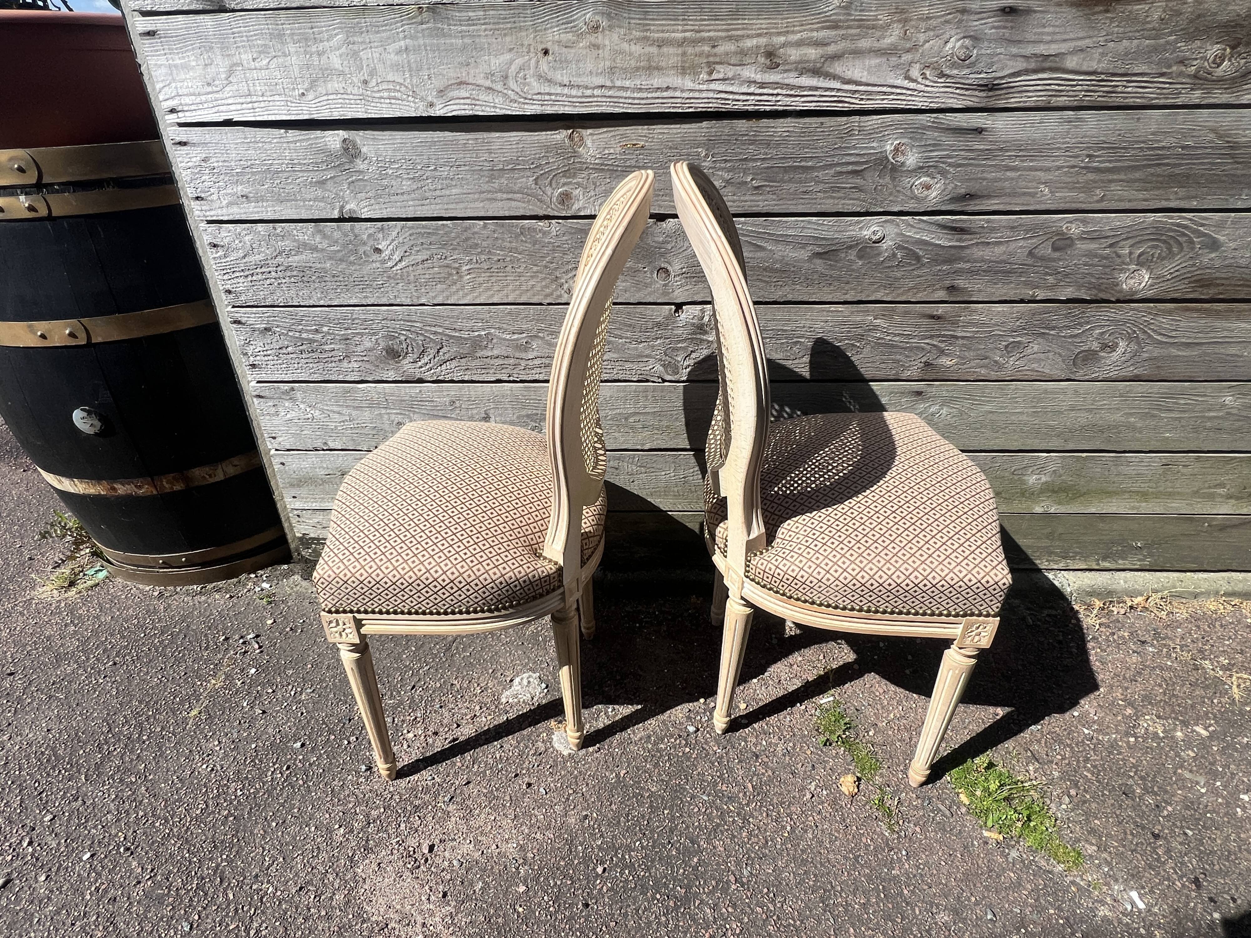 Pair of cerused chairs with fabric seats and caned backs.