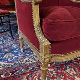 Golden wooden bergère in Louis XVI style upholstered in Bordeaux velvet.