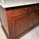 Antique wood and marble kitchen sideboard with carved backsplash