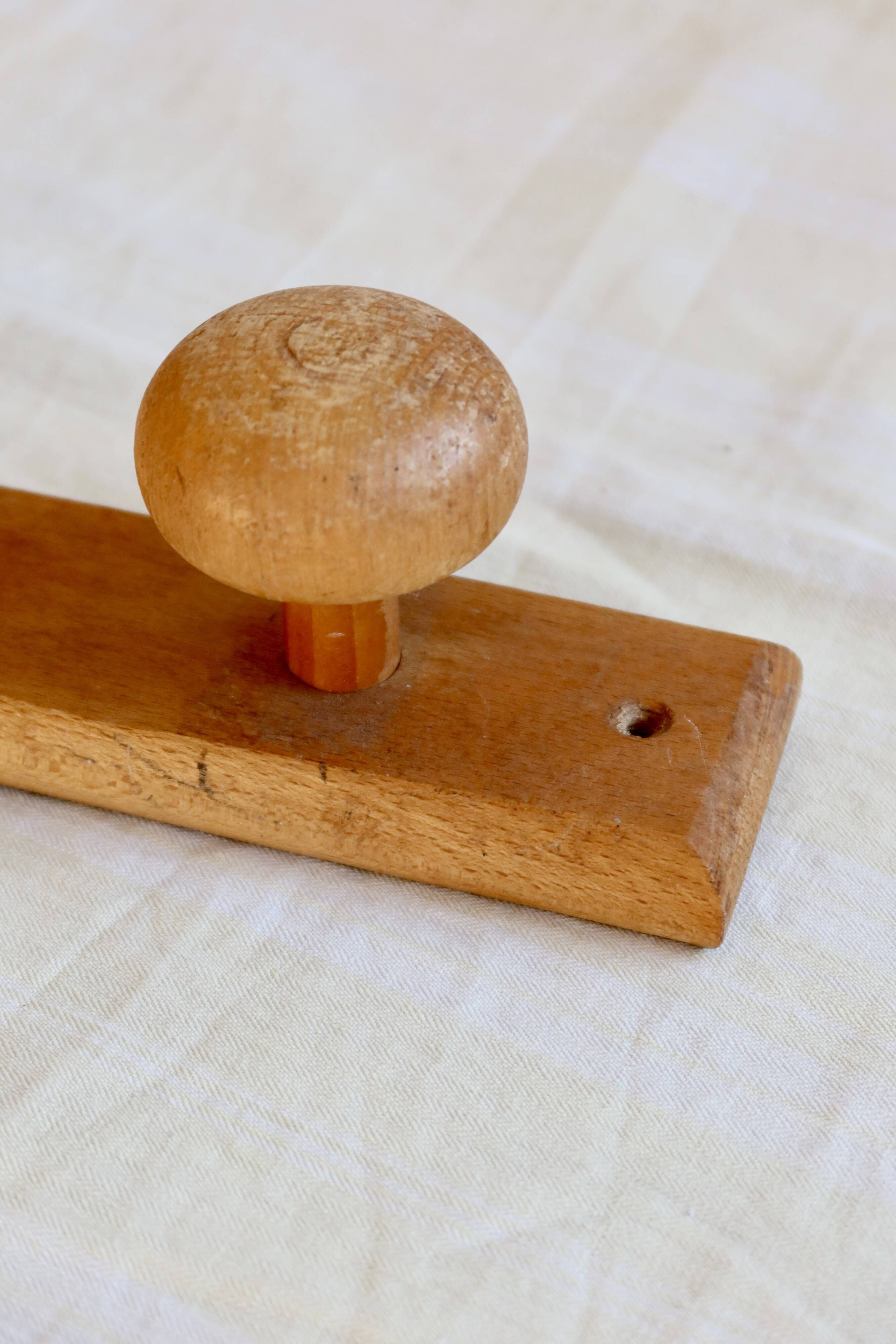 Vintage wooden coat rack with two round hooks.
