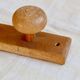Vintage wooden coat rack with two round hooks.