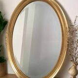 Beveled oval mirror with carved gilded wood frame