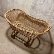 Vintage wicker cradle on wheels