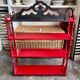 Wall shelf with 4 red lacquered wooden shelves.