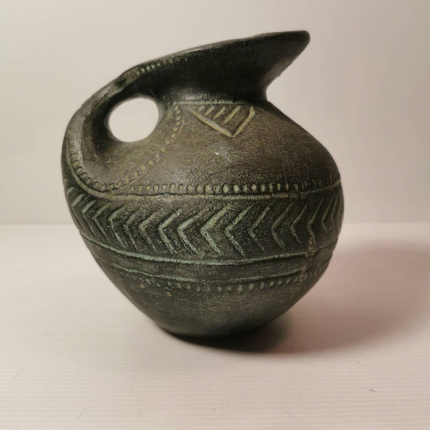 Vintage native american jug pot with geometric patterns in green / gray tones