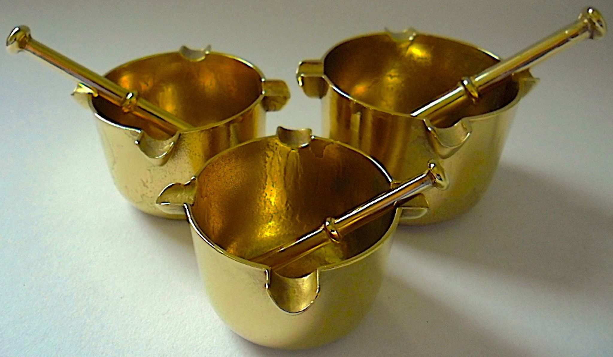 Three "vintage" bronze ashtrays with golden natural patina forming mortars with their drumsticks