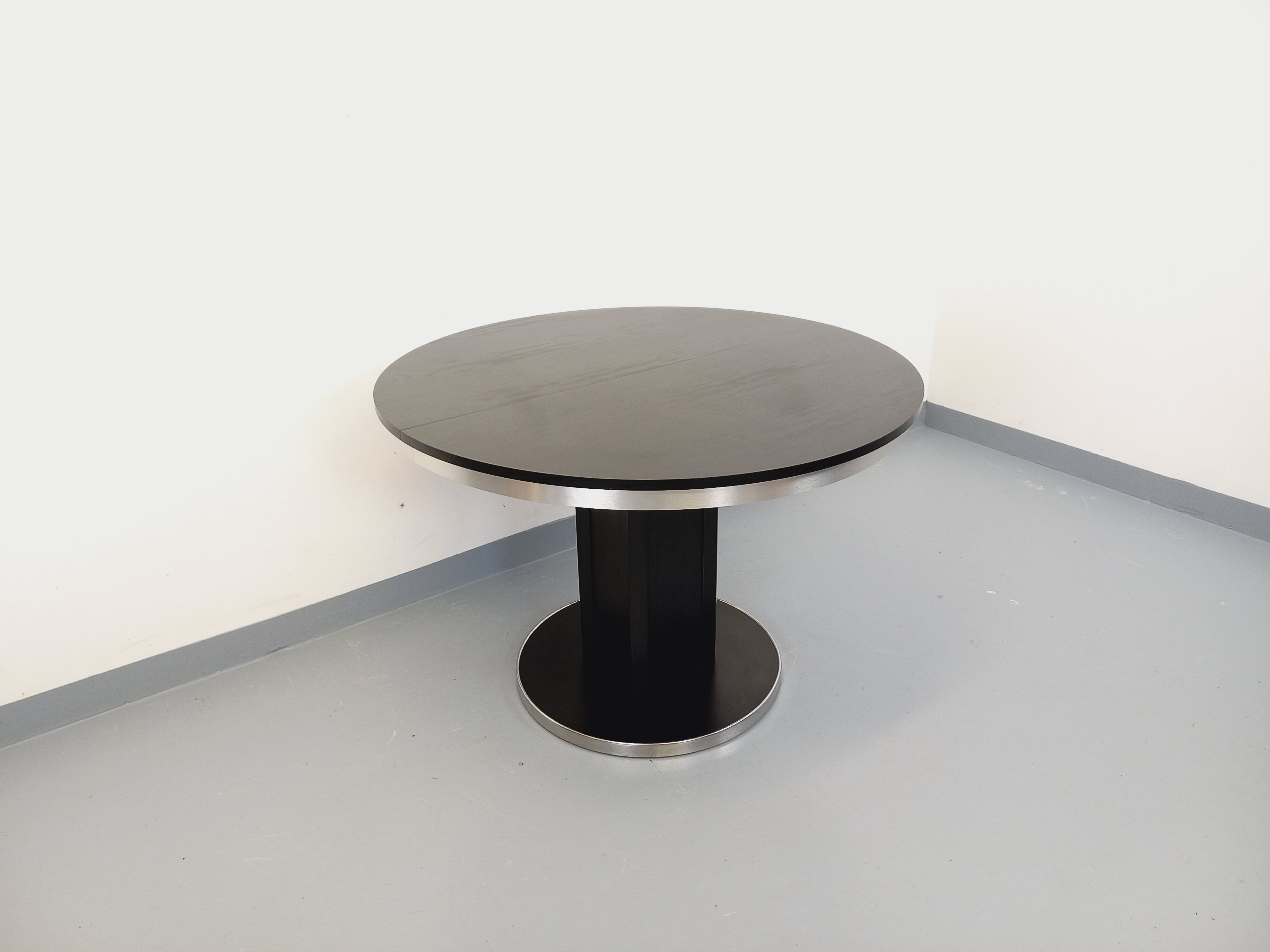 Vintage dining table in melamine with a black wood effect and chrome metal.