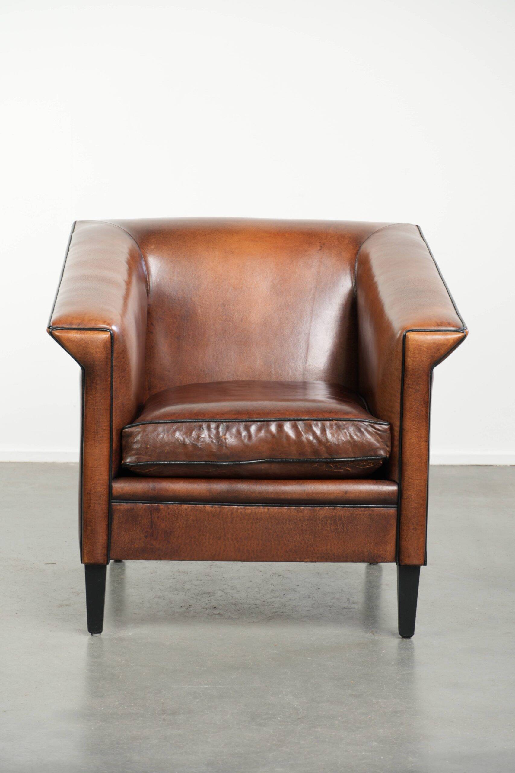 Sleek sheepskin Art Deco design armchair with black piping
