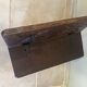 Small antique wooden bench with a folding backrest.