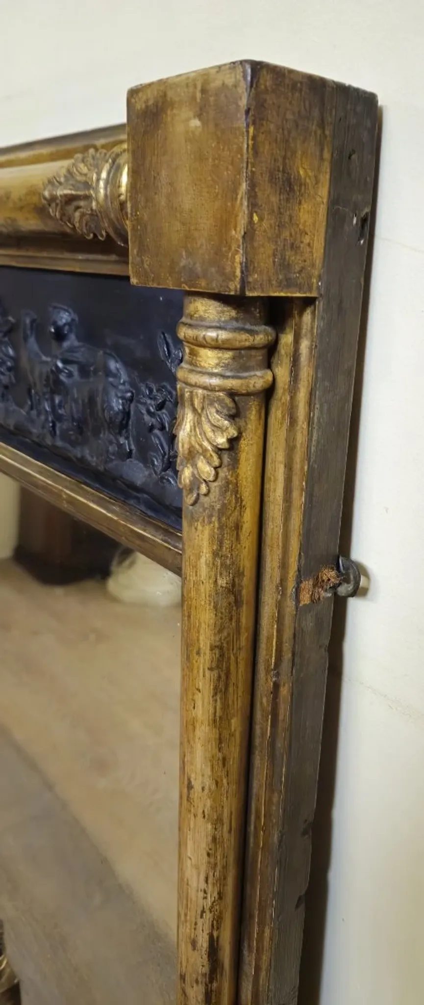 Large antique gilded wooden mirror with terracotta relief from the Empire period.