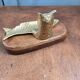 Vintage cat fish catchall in brass on a solid wood base.