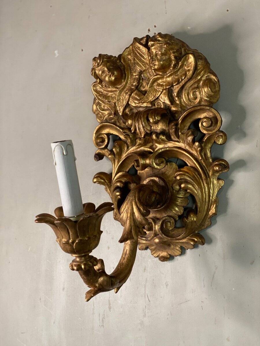 Paire d’appliques en bois sculpté et doré surmontées de deux têtes d’angelots, Italie