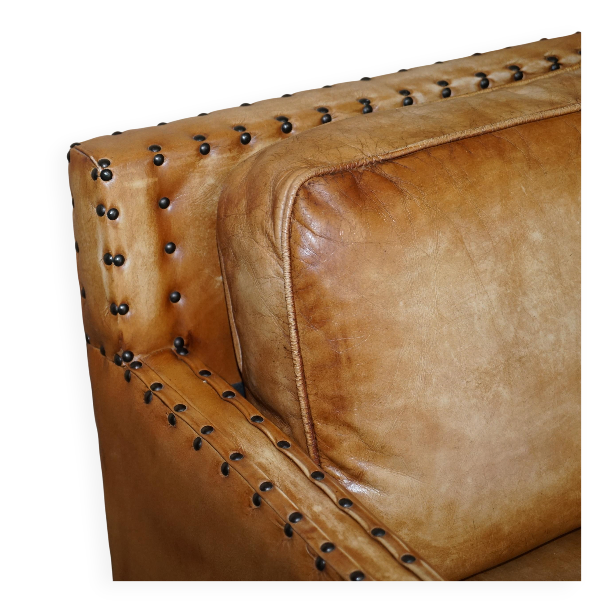 Three-seater leather canapé in Edwardian style with studs.