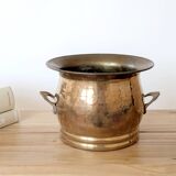 Vintage round cache-pot in hammered brass with decorative handles and patina.