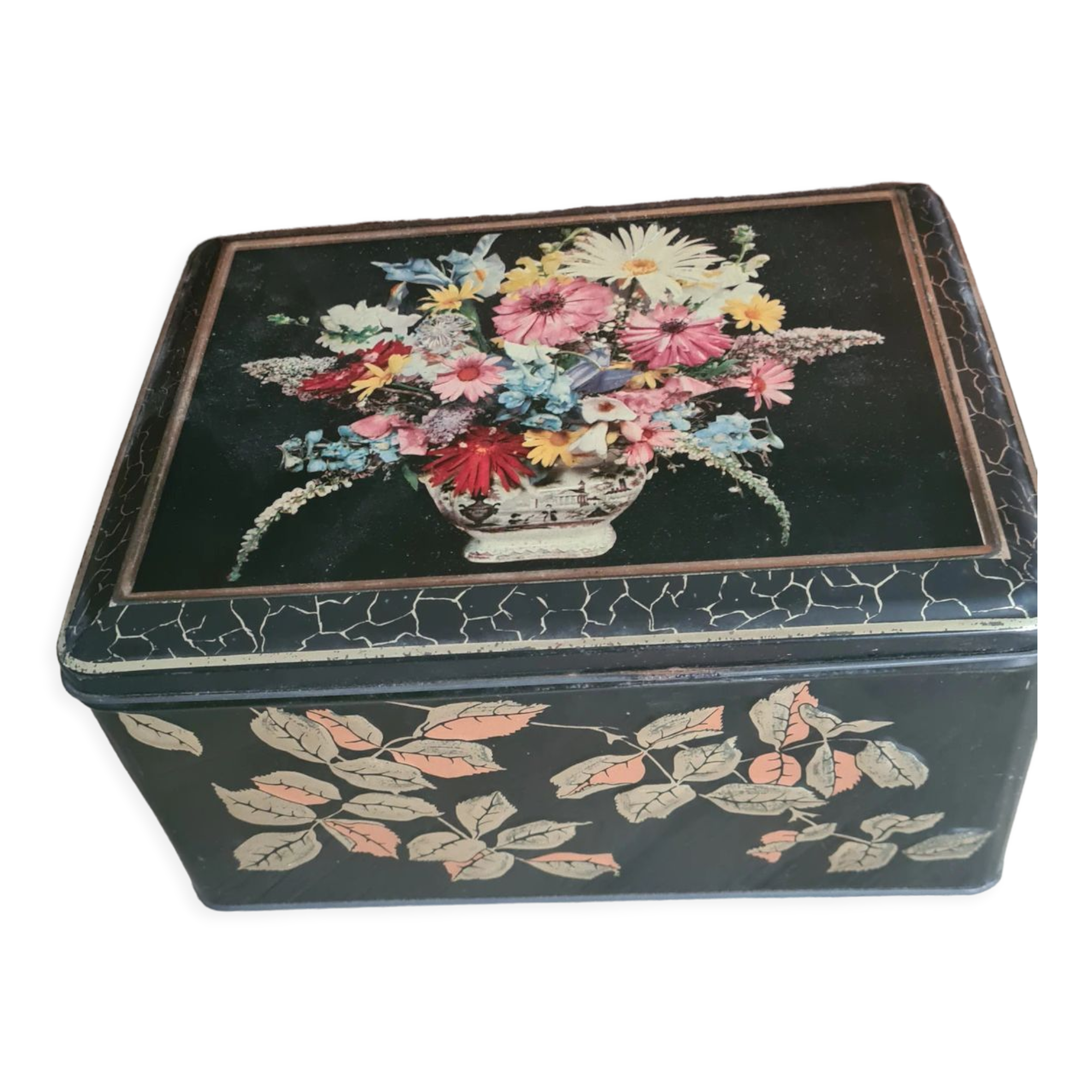 Old black metal box and flowers at the beginning of the century