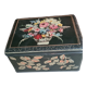 Old black metal box and flowers at the beginning of the century