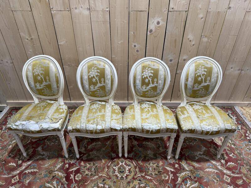Suite de 4 chaises médaillons de style Louis XVI rechampi blanc cassé