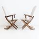 Pair of varnished wooden reclining armchairs, upholstered in lightweight fabric.