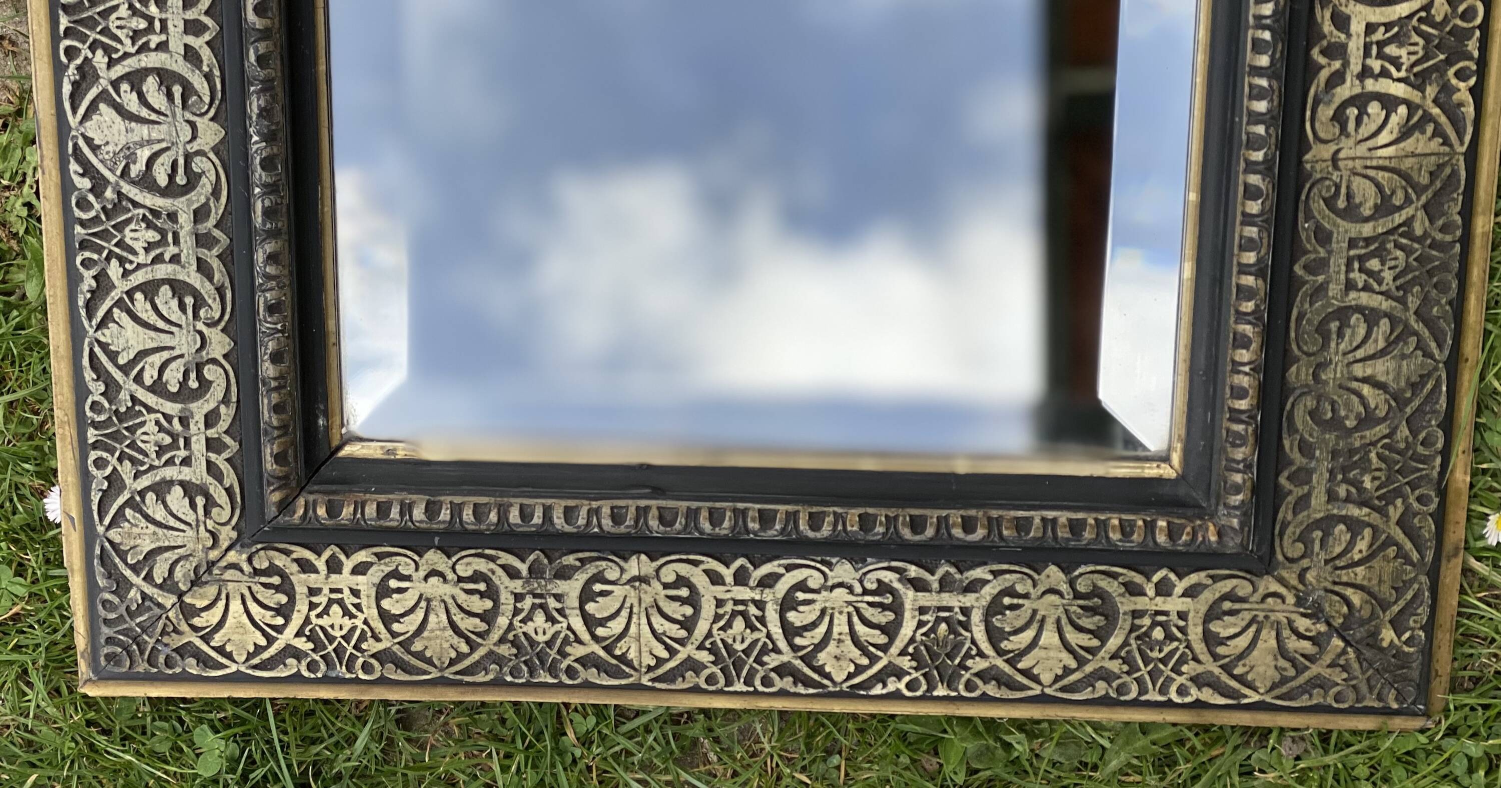 Bevelled mirror from the 19th century with gold and black palmettes.