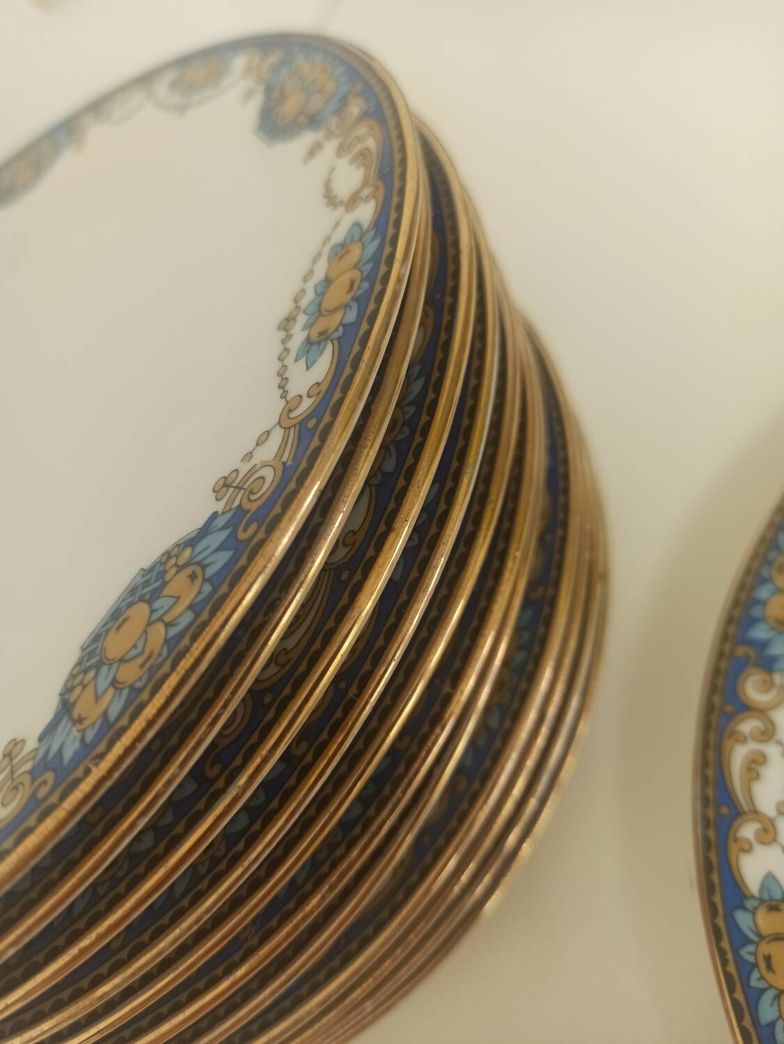 12 assiettes en porcelaine de Limoges à décor de guirlandes et de fruits