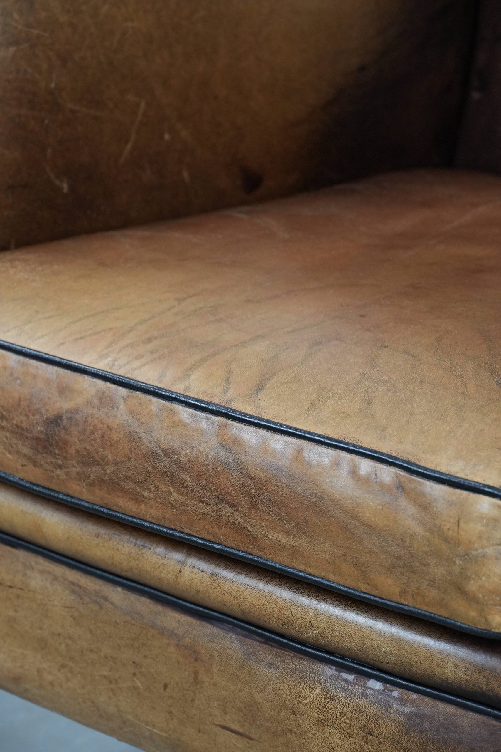 Large and comfortable sheepskin leather wingback chair with black piping