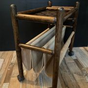 Porte revue en rotin vintage sur roulettes