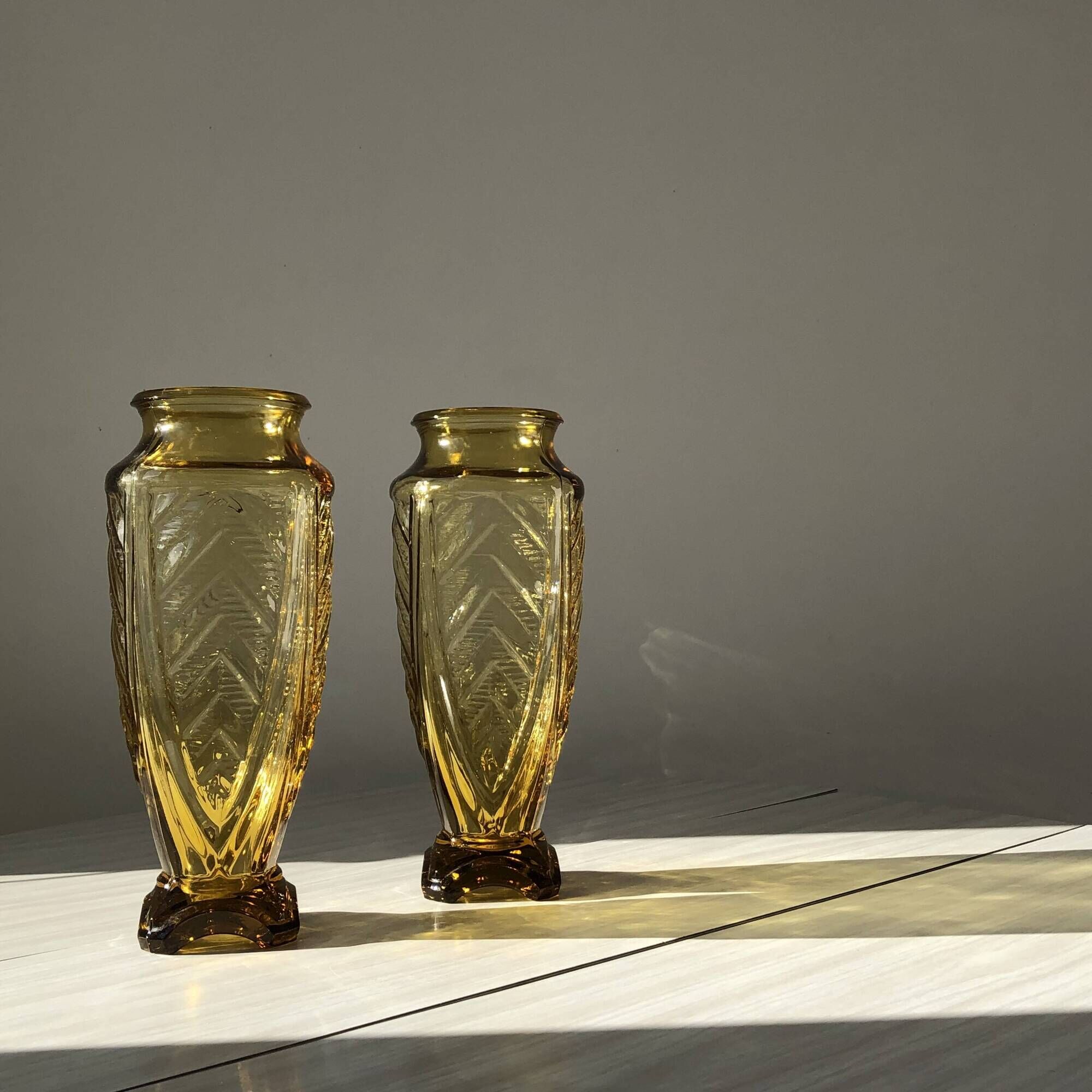 Duo of art deco vases in yellow glass with scroll patterns