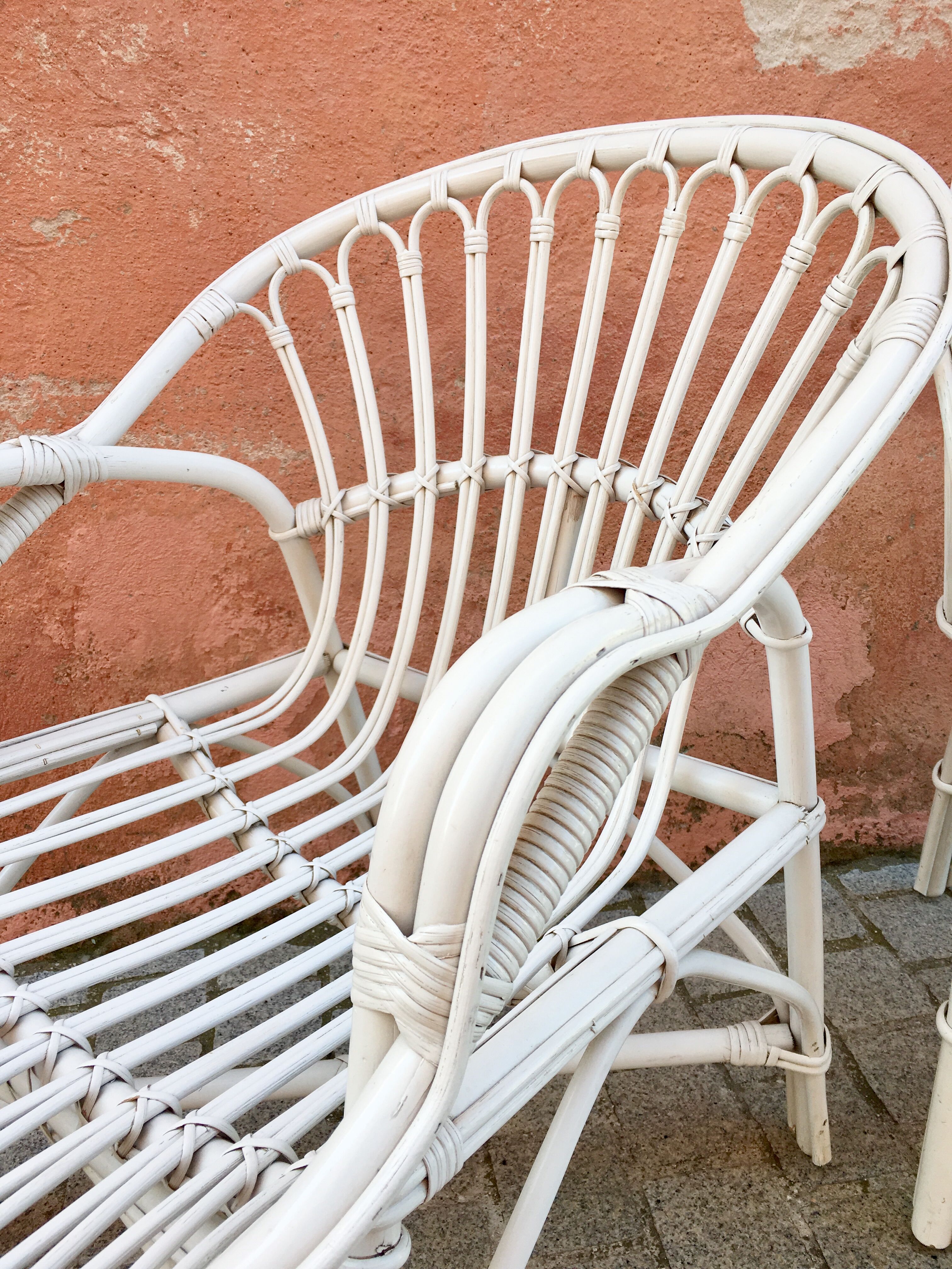 Two white rattan armchairs
