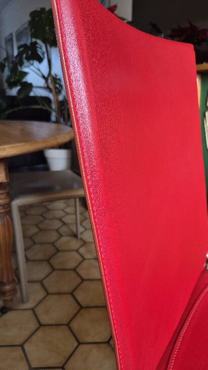 Red leather dining chairs by Arper