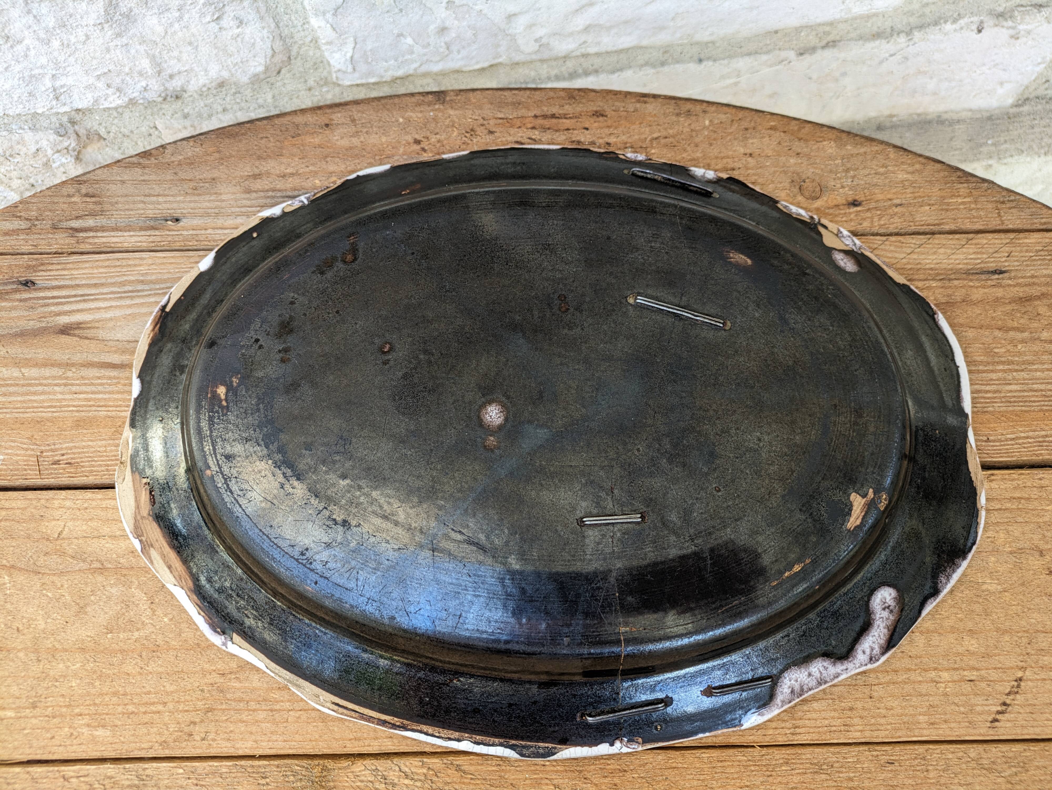 Old oval dish with floral motif called black bottom with staples
