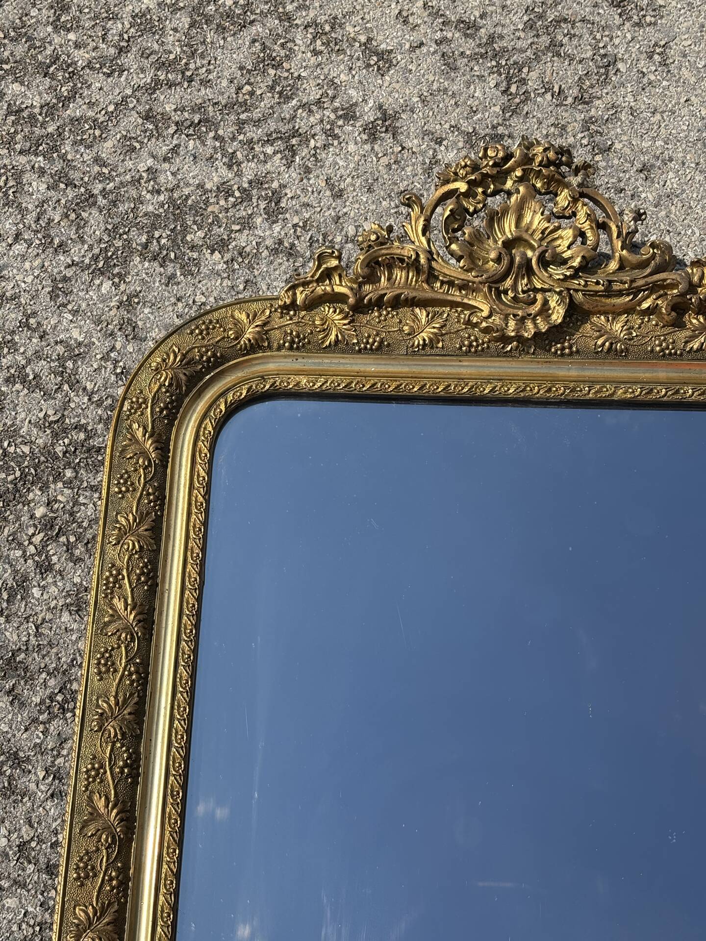 Golden mirror with a pediment from the early 20th century.