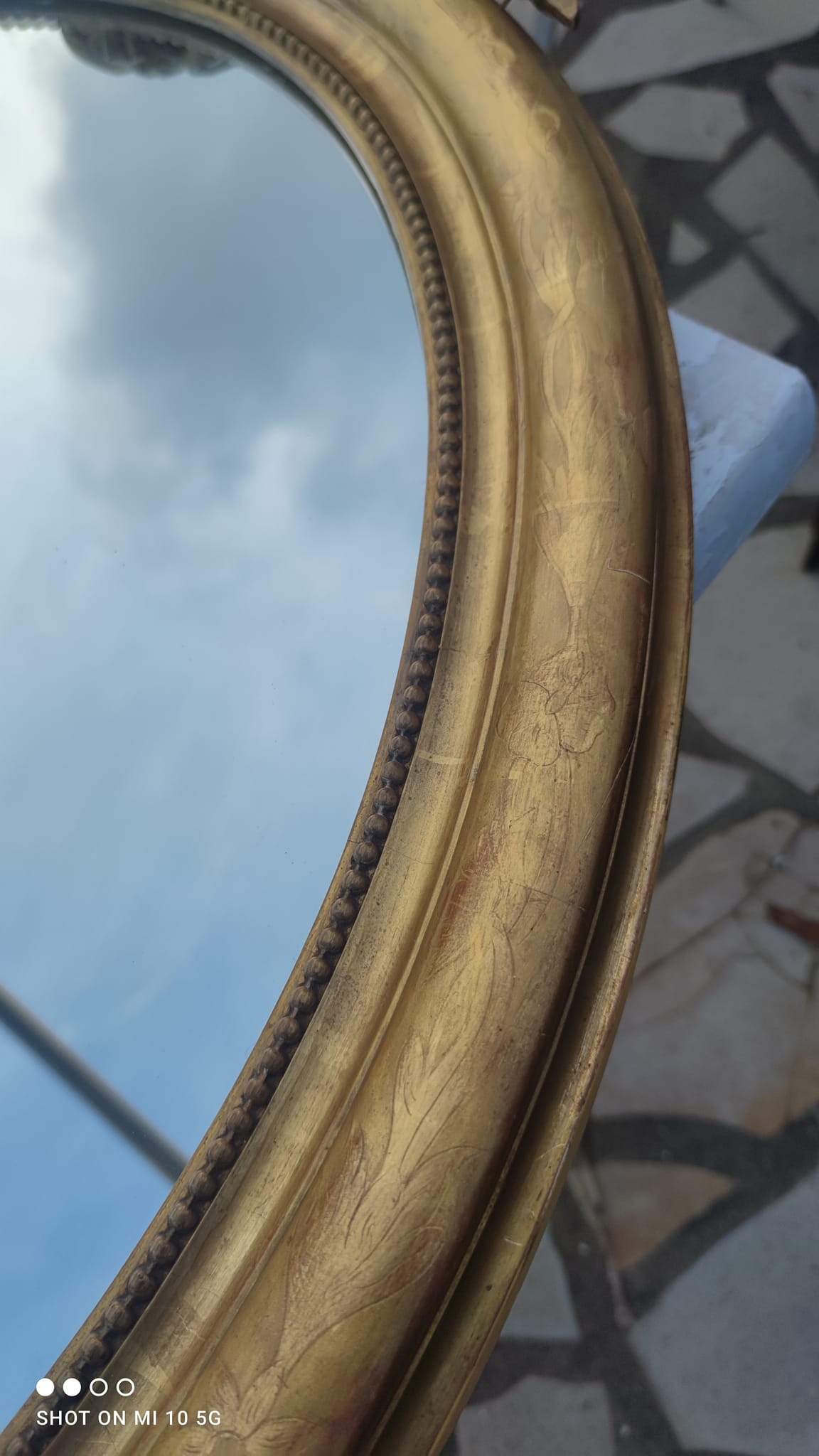 Ovoid mirror with double gilt pediments, circa 1830, 105x66 cm