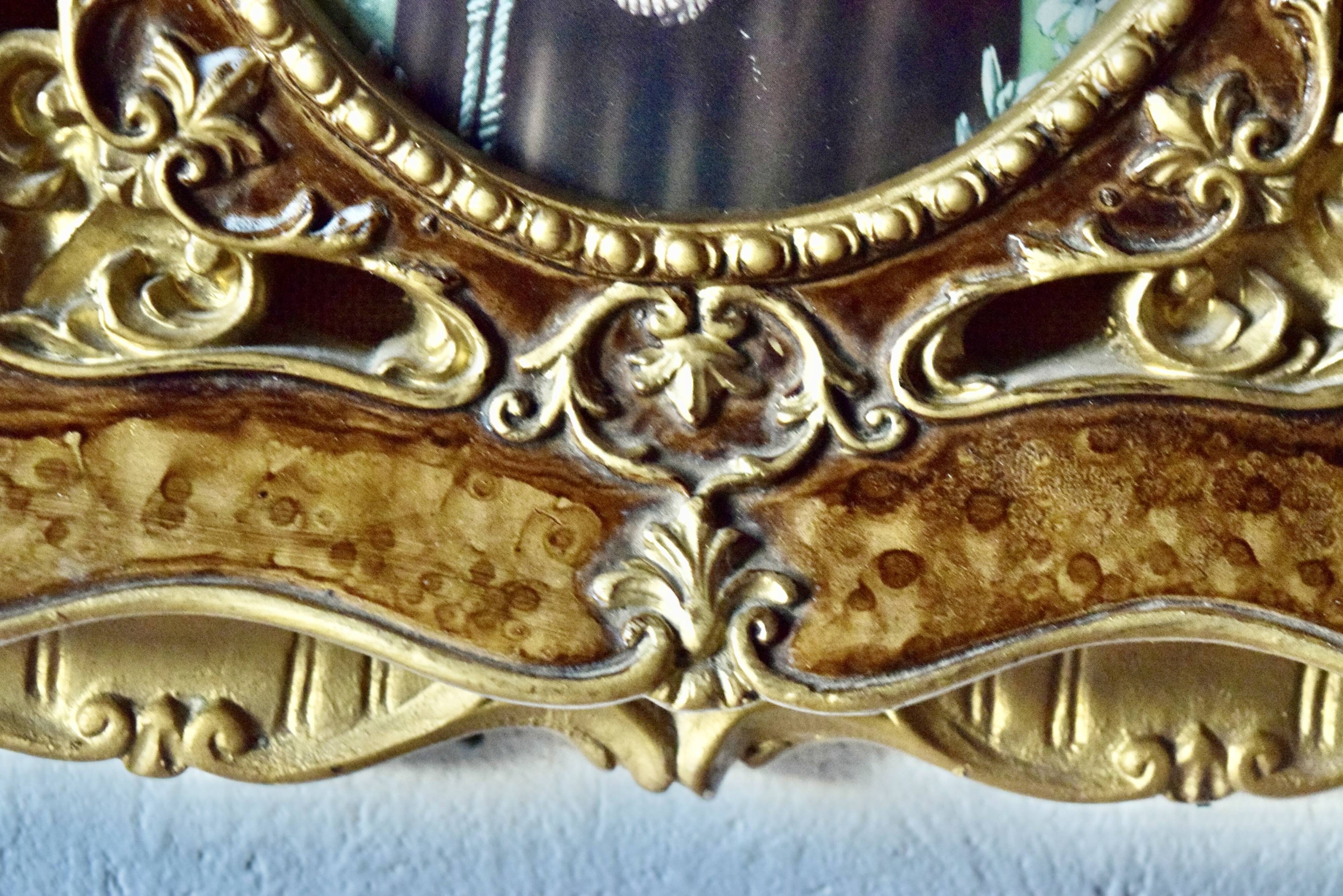 Old religious light frame in gilded stucco and curved glass