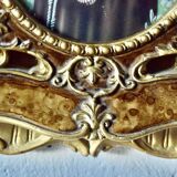 Old religious light frame in gilded stucco and curved glass