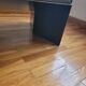 Minimalist/industrial coffee table with a black metal frame and a grey fabric top.