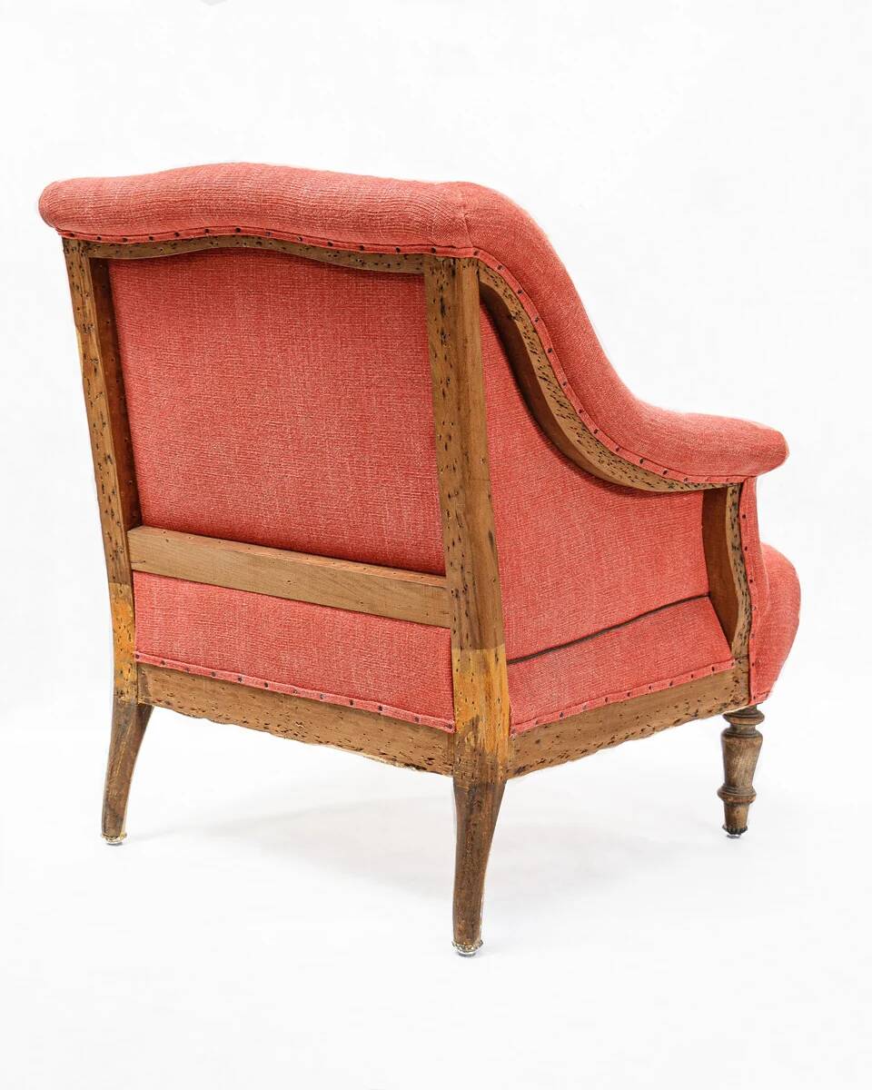 Napoleon III salon armchair in brick red linen with a tufted footrest.