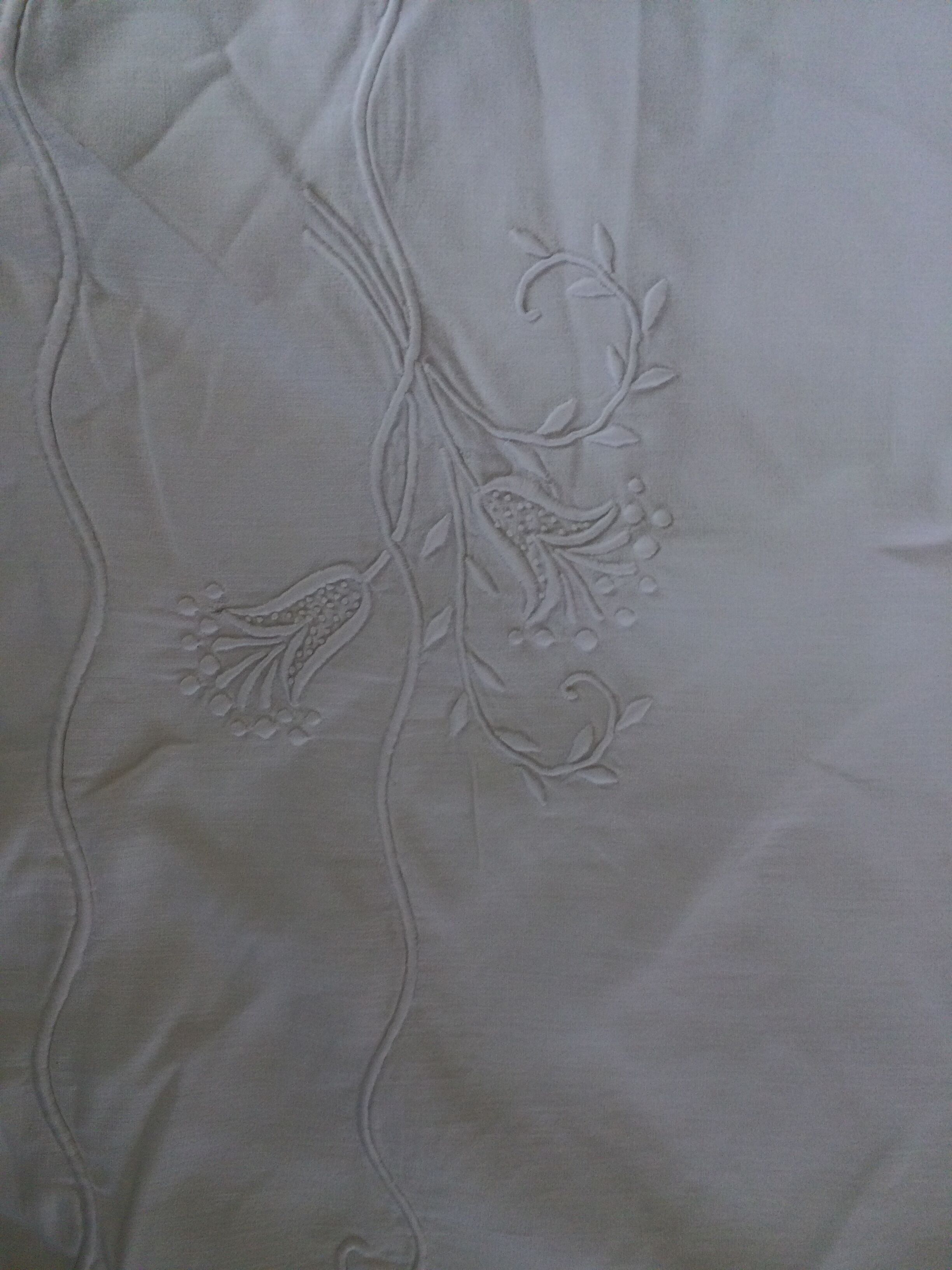 Old sheet with hand made embroidery, shaped flowers.