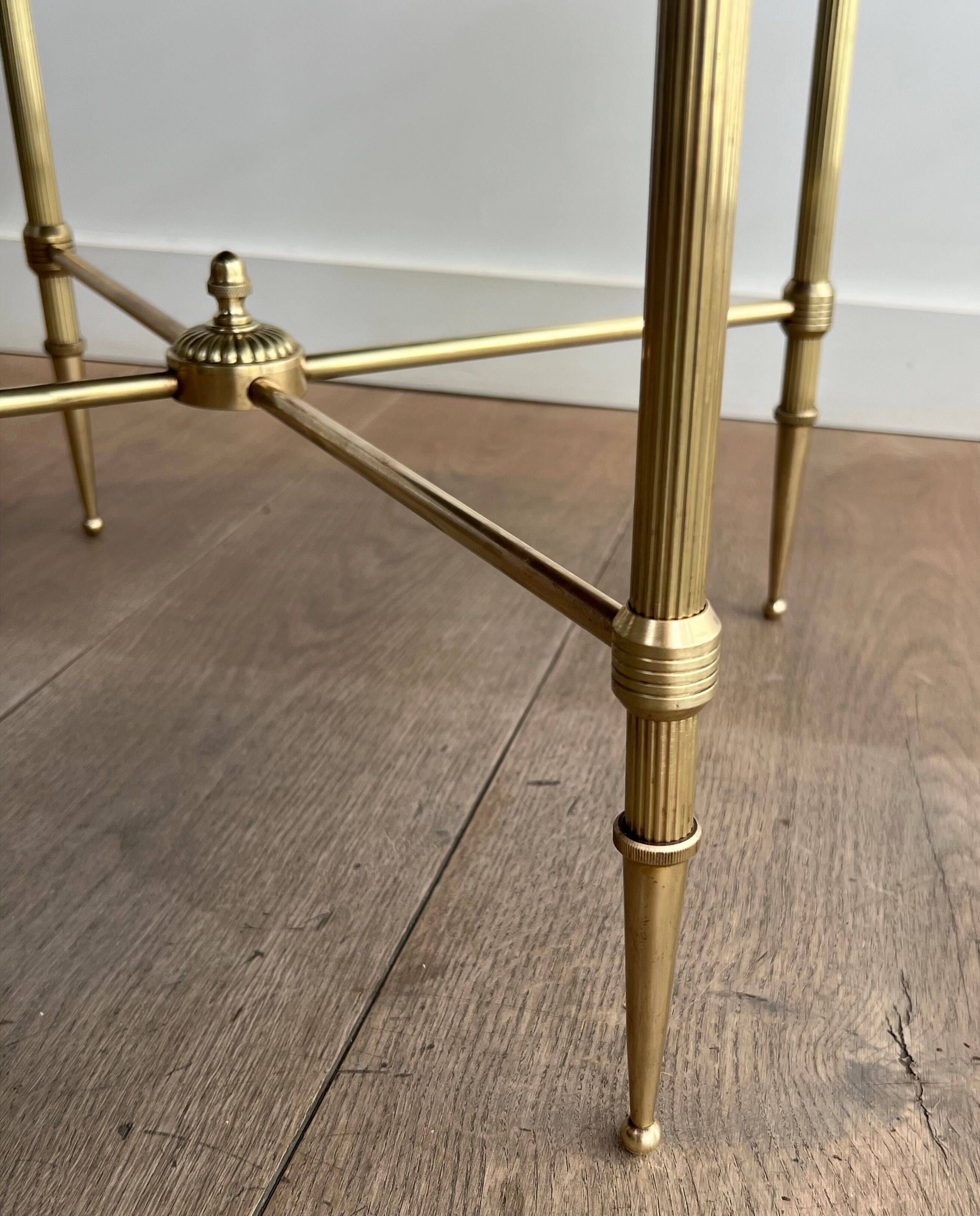 Round coffee table in brass with a black lacquered glass top from Maison Jansen.