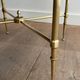 Round coffee table in brass with a black lacquered glass top from Maison Jansen.