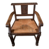 Antique armchair in carved wood with a straw seat.