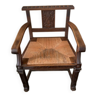 Antique armchair in carved wood with a straw seat.