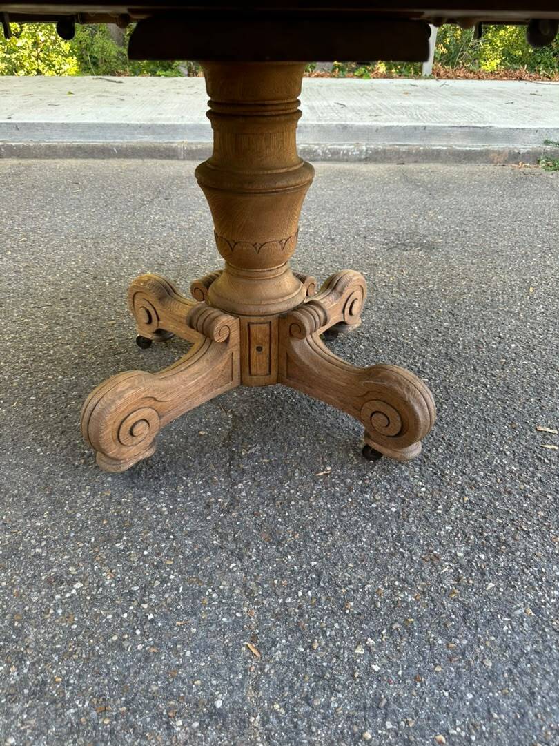 Round dining table with a central pedestal, stripped raw oak, 4 extensions, 19th century.