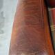 Very large worn sheepskin wing chair with a checked seat cushion