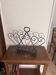 Vintage 1950s black wrought iron magazine rack with scroll decorations.