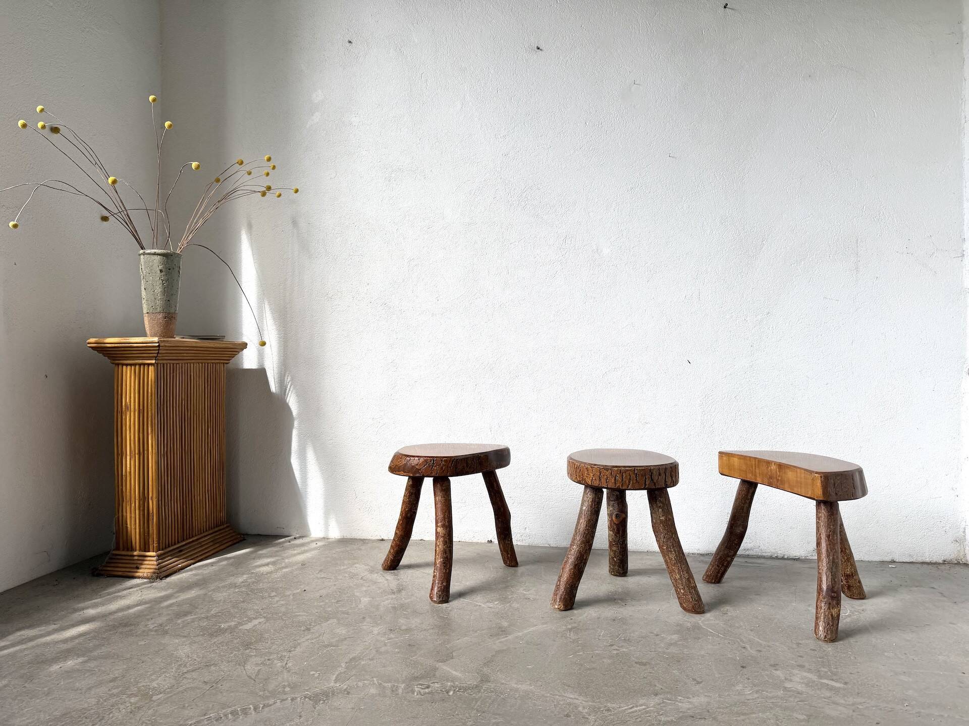 Set of three rustic solid wood tripod stools.