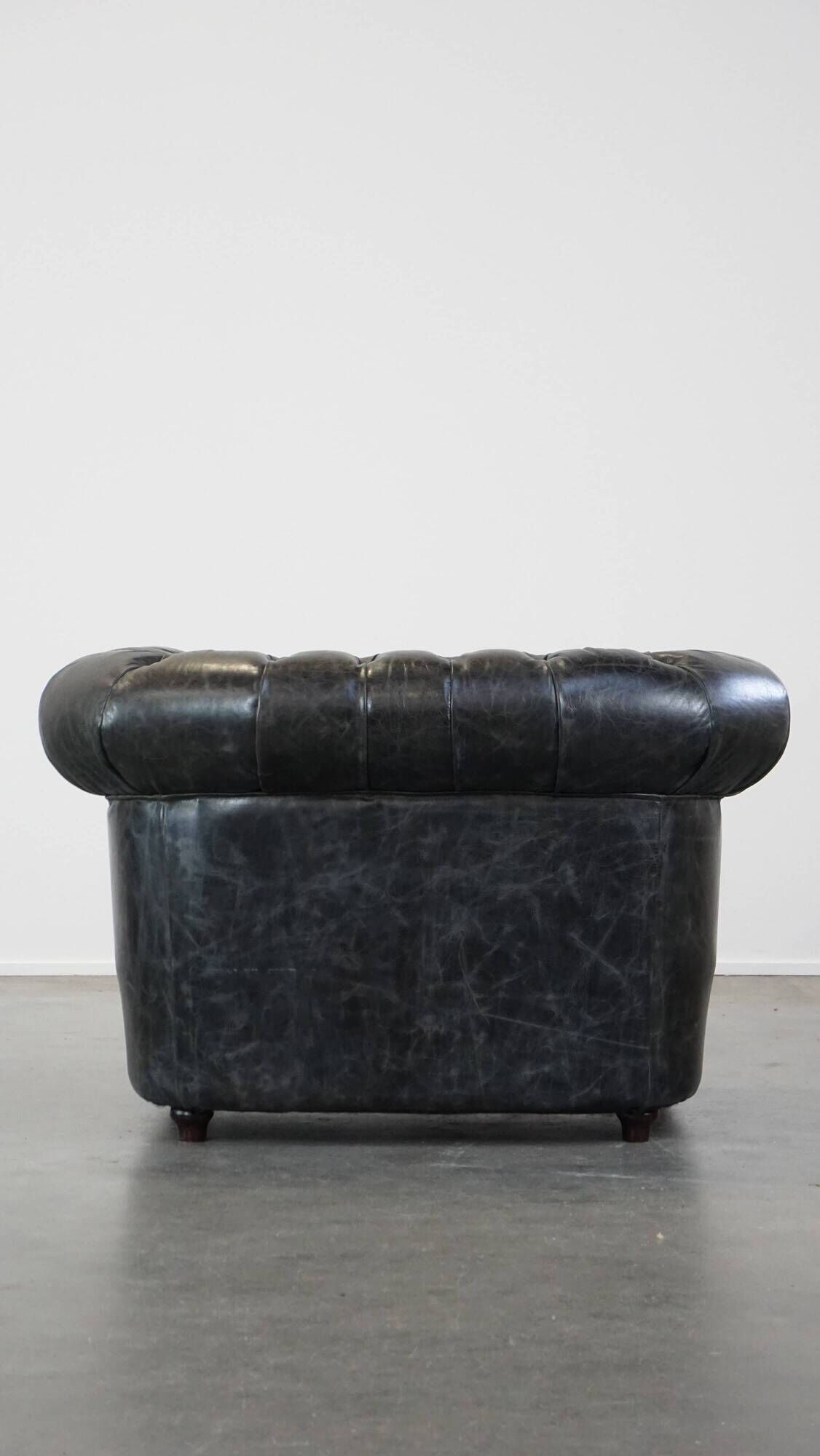 Spacious black cow leather chesterfield armchair with distinctive character