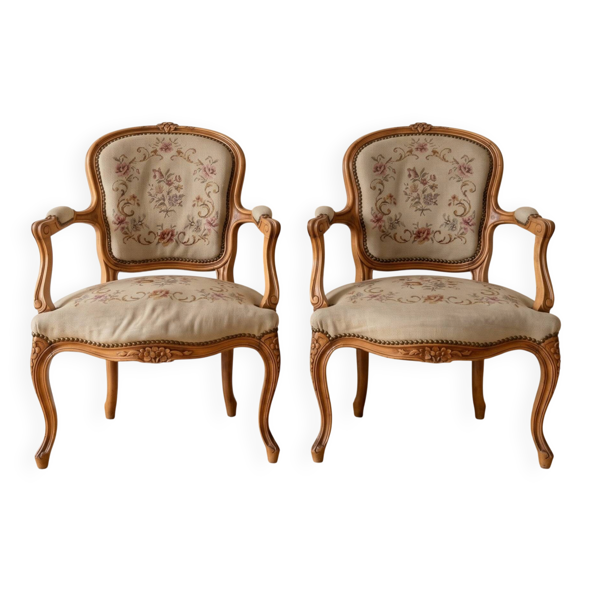 Pair of Louis XV/XVI armchairs in carved wood and floral fabric.